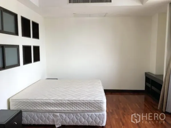 อพาร์ทเมนท์ ให้เช่าในRatchathewi, Bangkok - ห้องนอนใหญ่พร้อมที่นอนขนาดควีน พื้นไม้ และผนังตกแต่ง