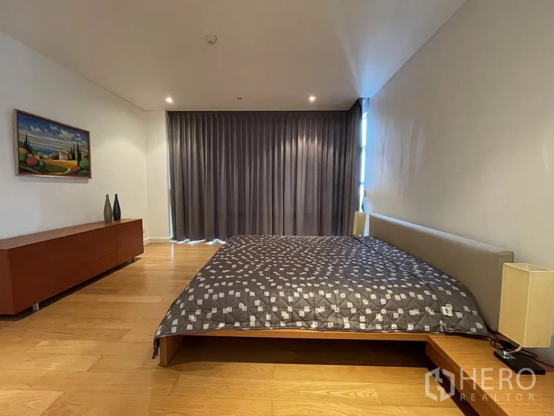 คอนโด ให้เช่าหรือขายในWatthana, Bangkok - มุมหน้าห้องนอนหลัก ม่านยาว ตู้วางของทรงเตี้ย และพื้นไม้โทนอุ่น.