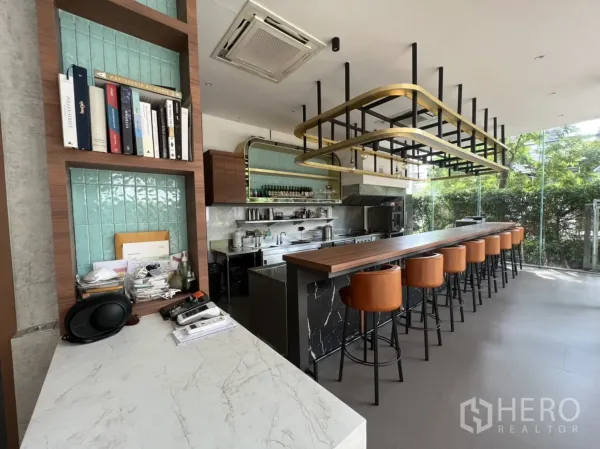 พื้นที่ขายปลีก ให้เช่าในWatthana, Bangkok - ภาพภายในพื้นที่ค้าปลีกพร้อมใช้งาน มีเคาน์เตอร์ไม้ยาว เก้าอี้สตูลหนัง ครัวเปิด และผนังกระจกใส