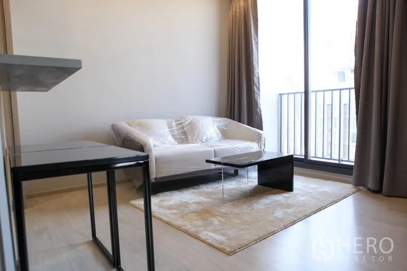 公寓 出租在Watthana, Bangkok - 客厅配双人沙发、茶几与通向阳台的落地窗