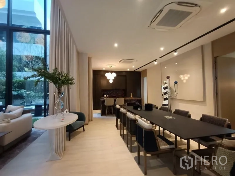 บ้าน ขาย - โซนรับประทานอาหารยาว โต๊ะตัวใหญ่ พร้อมแพนทรีบาร์ และหน้าต่างสูงผ้าม่านทิ้งตัว