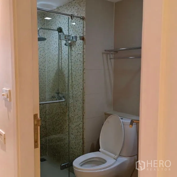 Condominium for rent in Watthana, Bangkok - Guest bathroom with glass shower enclosure and modern toilet in an Ekkamai condo.