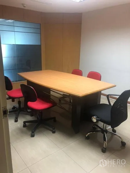 办公空间 出租在Sathon, Bangkok - 小型会议室，椭圆形会议桌与滚轮椅，旁有玻璃隔断。