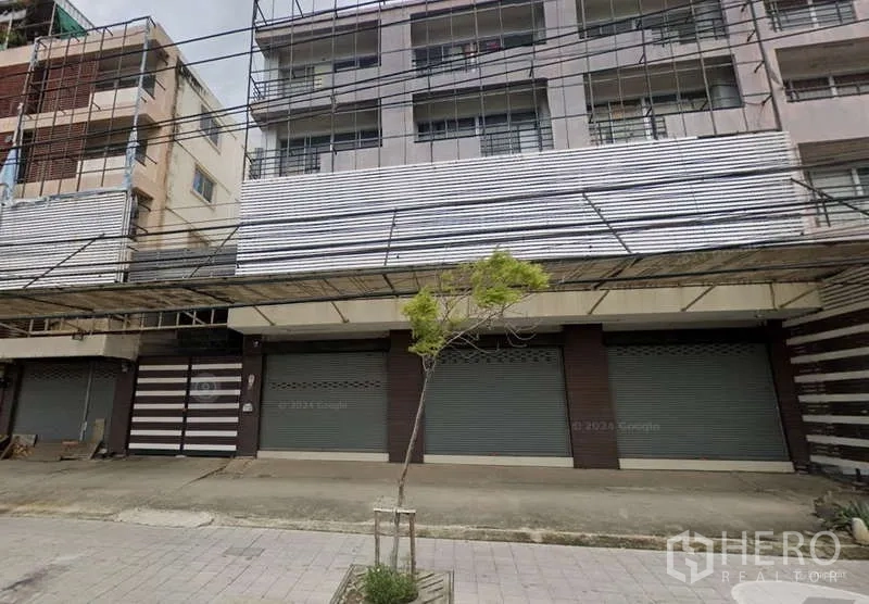 Shophouse for rent or sale in Bang Khun Thian, Bangkok - Another facade view of the shophouse row with metal shutters and an overhead canopy.