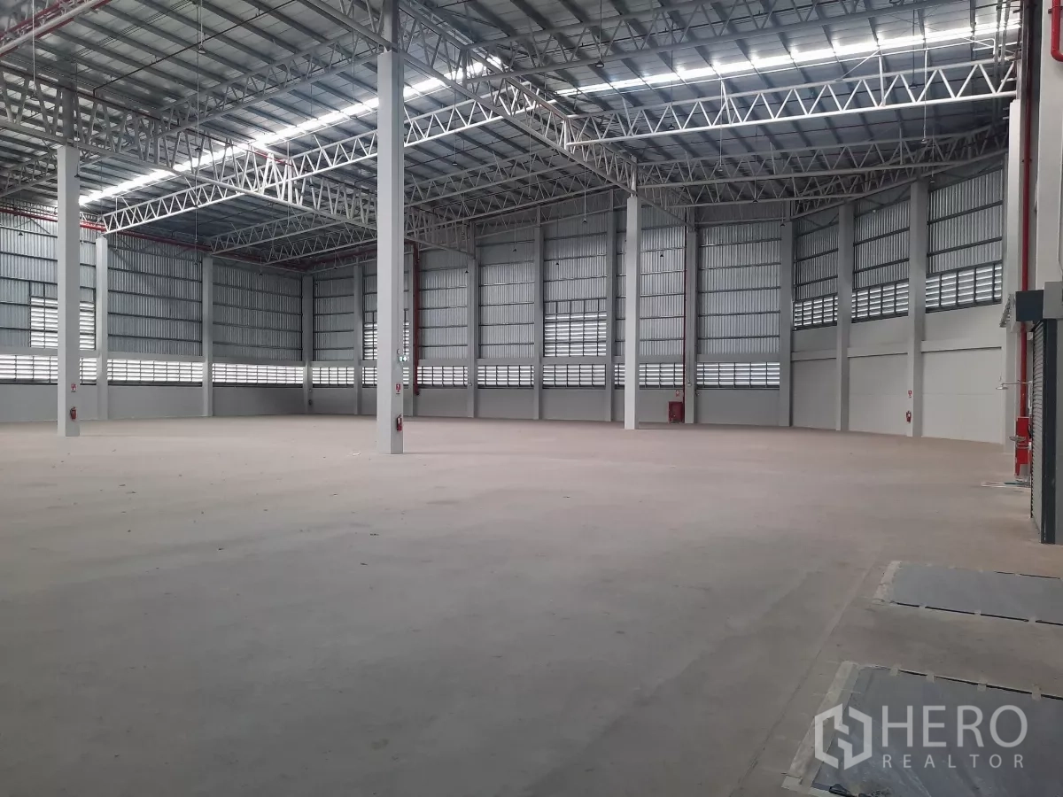 Factory for rent in Bang Lamung, Chon Buri - Open warehouse bay highlighting fire sprinklers and emergency exits.
