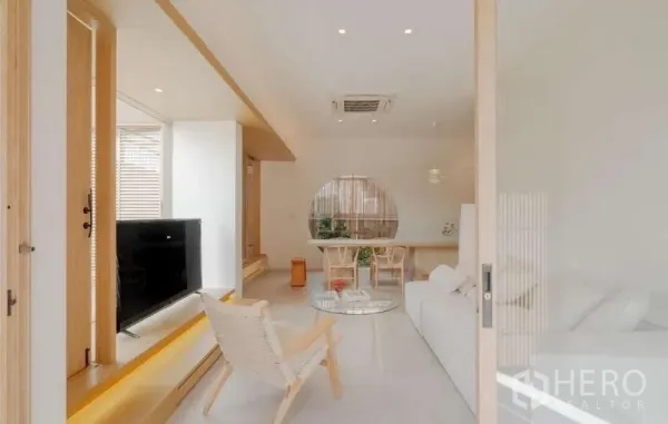 独立式住宅 出售在Bang Phli, Samut Prakan - 通透明亮的客餐厅，白色沙发、电视柜与原木风格