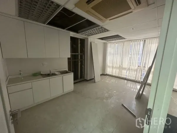 办公空间 出租在Khlong Toei, Bangkok - 办公室茶水间，白色橱柜与水槽，瓷砖地面，吊顶及竖百叶窗。