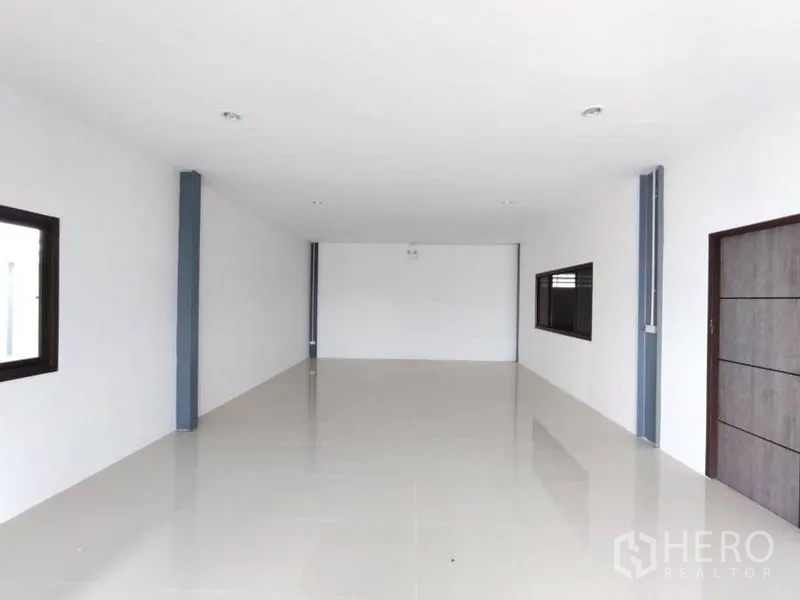 Warehouse for rent in Bang Phli, Samut Prakan - Empty white office room with windows on both sides and ceramic tiled flooring.