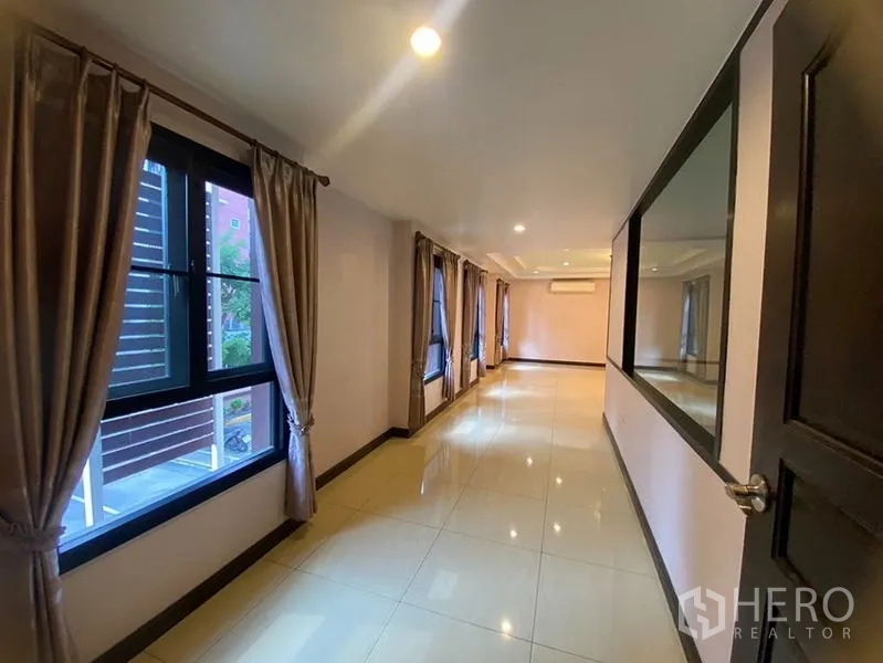 Home Office for rent in Don Mueang, Bangkok - Long corridor with tiled floor, windows and wall mirror.