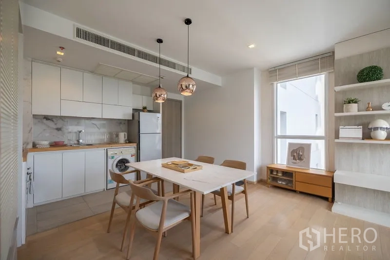 Condominium for rent in Watthana, Bangkok - TV wall with floating shelves opposite the sofa, with balcony and skyline beyond.