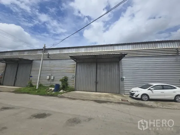 คลังสินค้า ให้เช่าในBang Phli, Samut Prakan - ด้านหน้าโกดังผนังเมทัลชีทที่บางพลี ประตูเลื่อนขนาดใหญ่ มีที่จอดรถริมถนน