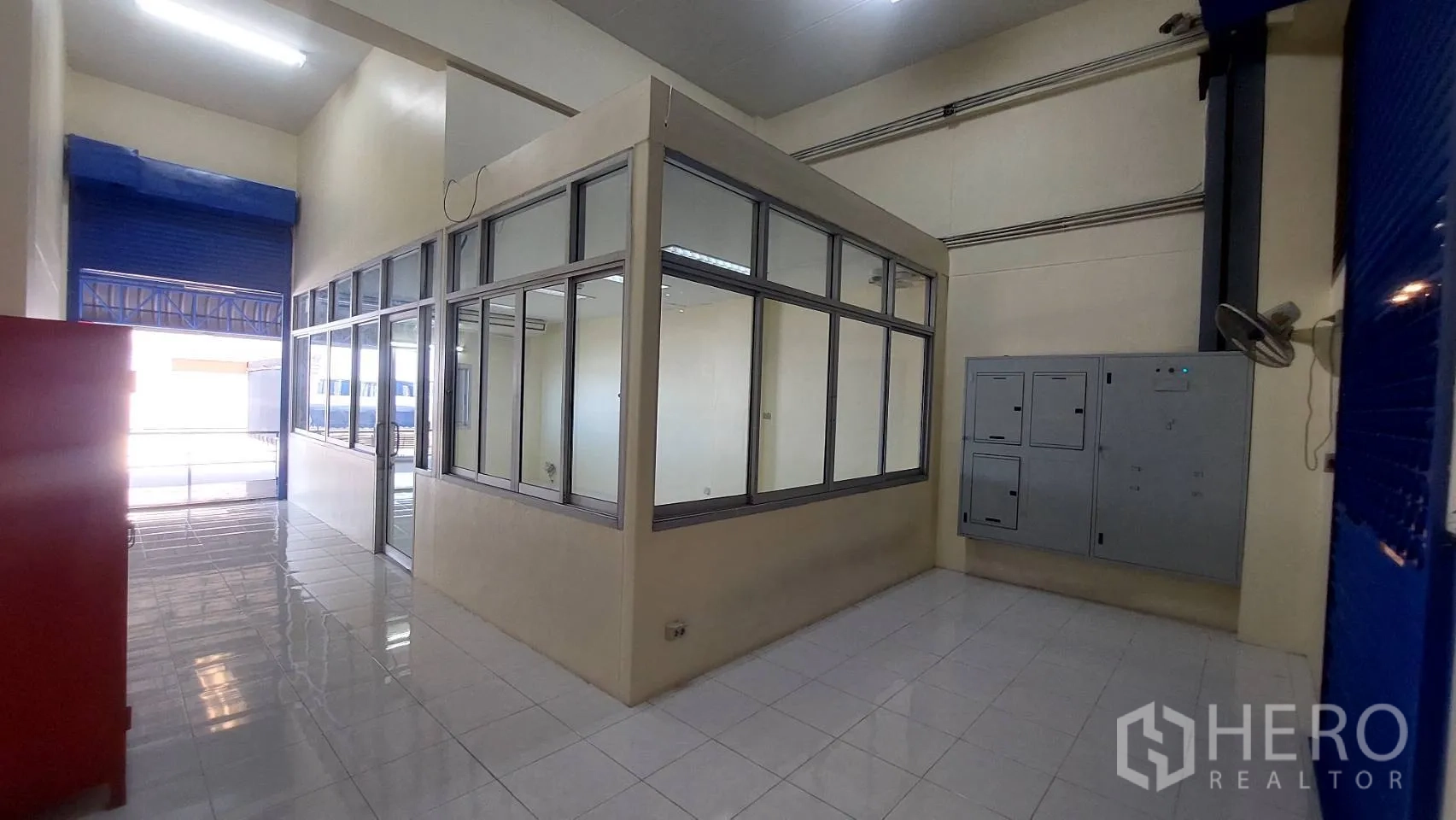 货栈 出租在Mueang Pathum Thani, Pathum Thani - 仓库内玻璃围合的主管办公室，邻近蓝色卷帘门。