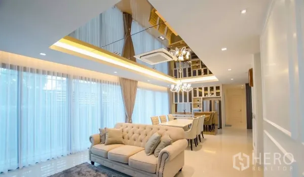 Detached House for rent in Bang Bon, Bangkok - Spacious living and dining area with floor-to-ceiling curtains and mirrored ceiling lighting.