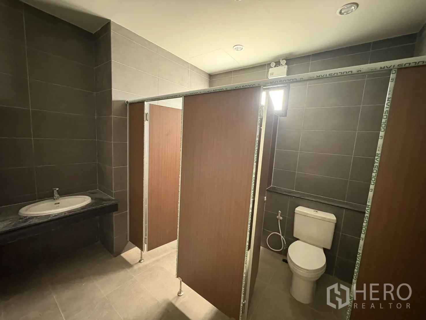 Factory for rent in Bang Pakong, Chachoengsao - Newly fitted restroom with sink, toilet, and partitioned stalls.