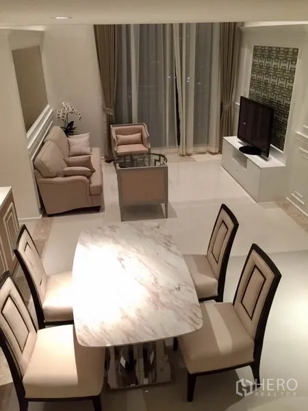 公寓 出租在Sathon, Bangkok - 沙吞公寓客餐厅，米色沙发与大理石餐桌，落地窗帘。