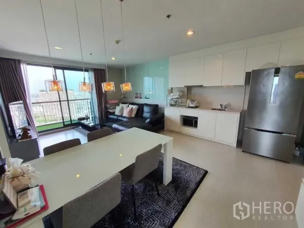 คอนโด ขายในKhlong Toei, Bangkok - ห้องนั่งเล่นและครัวแบบเปิด เชื่อมต่อระเบียง พร้อมหน้าต่างสูงจรดเพดาน