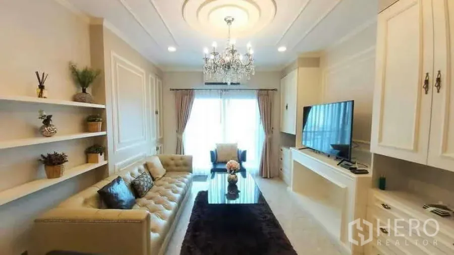 Condominium for rent in Khlong Toei, Bangkok - Full view of the living room featuring chandelier, shelving and large windows at The Crest Sukhumvit 34.