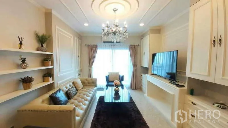 Condominium for rent in Khlong Toei, Bangkok - Full view of the living room featuring chandelier, shelving and large windows at The Crest Sukhumvit 34.