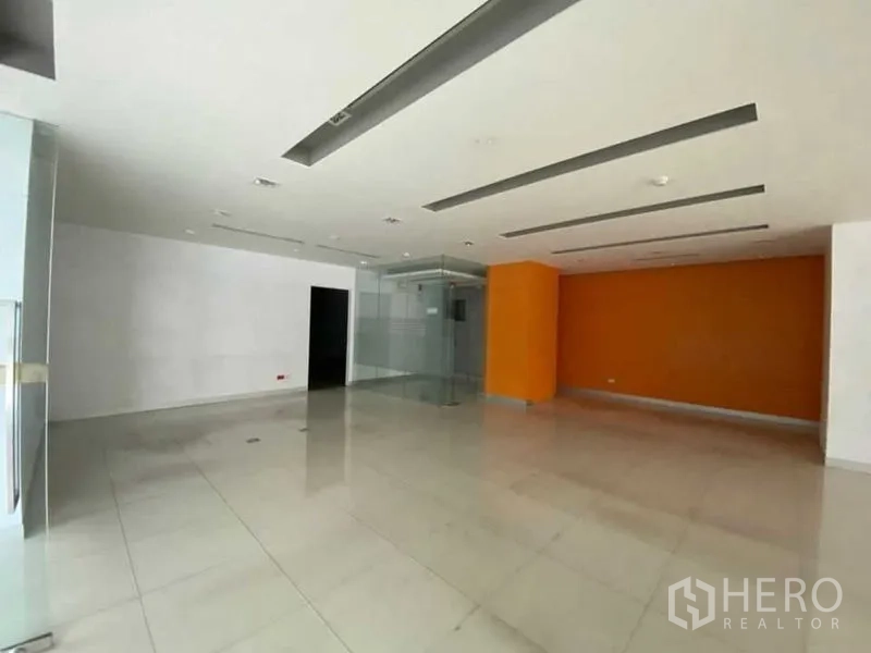 零售空间 出租 - 现代转角外立面，环幕玻璃与绿化带。