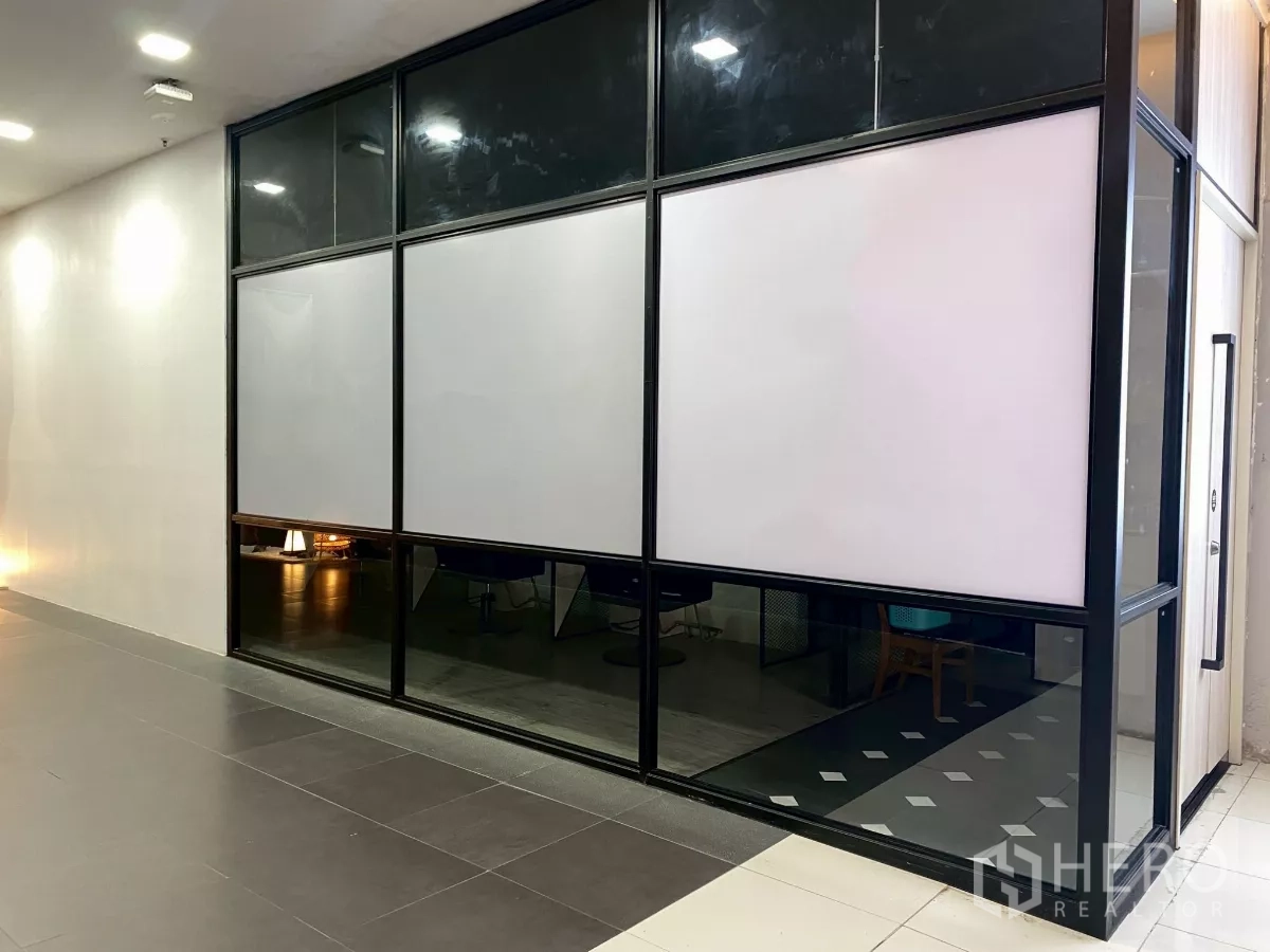 Retail Space for rent in Mueang Nakhon Pathom, Nakhon Pathom - Glass-front retail shop facade with black frame facing an indoor corridor.