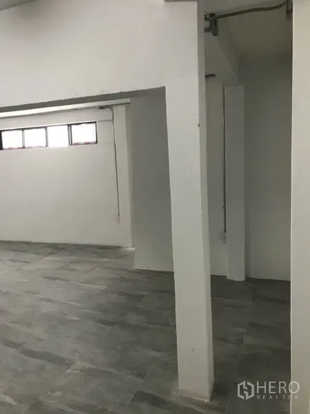 Office Space for rent in Watthana, Bangkok - Partitioned office zone with structural columns, grey floor tiles and narrow upper windows.