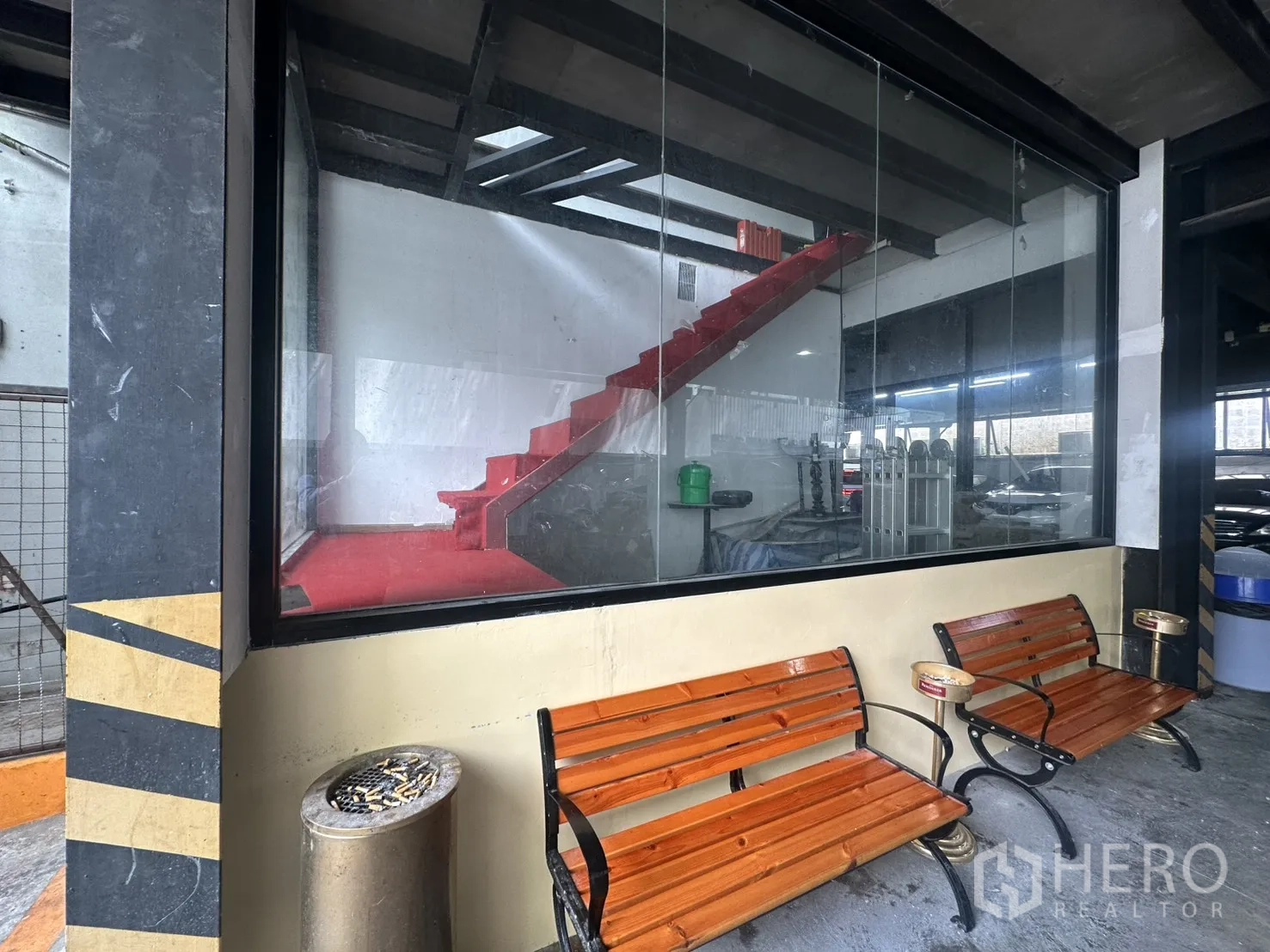 Retail Space for rent in Watthana, Bangkok - Large window facade revealing a red staircase inside with wooden benches outside.