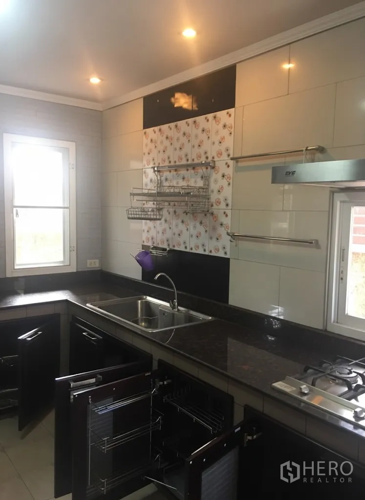 บ้าน ให้เช่าในLat Krabang, Bangkok - ครัวมุมใกล้ อ่างล้างจานสแตนเลส เตาแก๊ส ผนังกระเบื้อง และตะแกรงเก็บของ