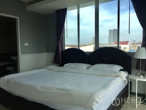 คอนโด ให้เช่าในKhlong Toei, Bangkok - ห้องนอนกว้าง เตียงหัวเตียงบุผ้าและหน้าต่างบานใหญ่เห็นวิวเมือง