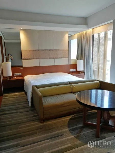 คอนโด ให้เช่าในPathum Wan, Bangkok - ห้องนอนคอนโดสว่าง เตียงขนาดใหญ่ โซฟา และหน้าต่างสูงจรดเพดาน