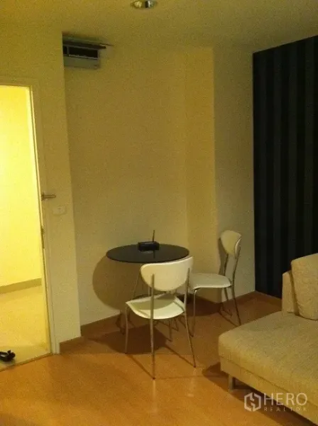 คอนโด ให้เช่าในWatthana, Bangkok - มุมรับประทานอาหารขนาดกะทัดรัด โต๊ะกลมกับเก้าอี้สองตัว ข้างโซฟาบนพื้นไม้โทนอ่อน