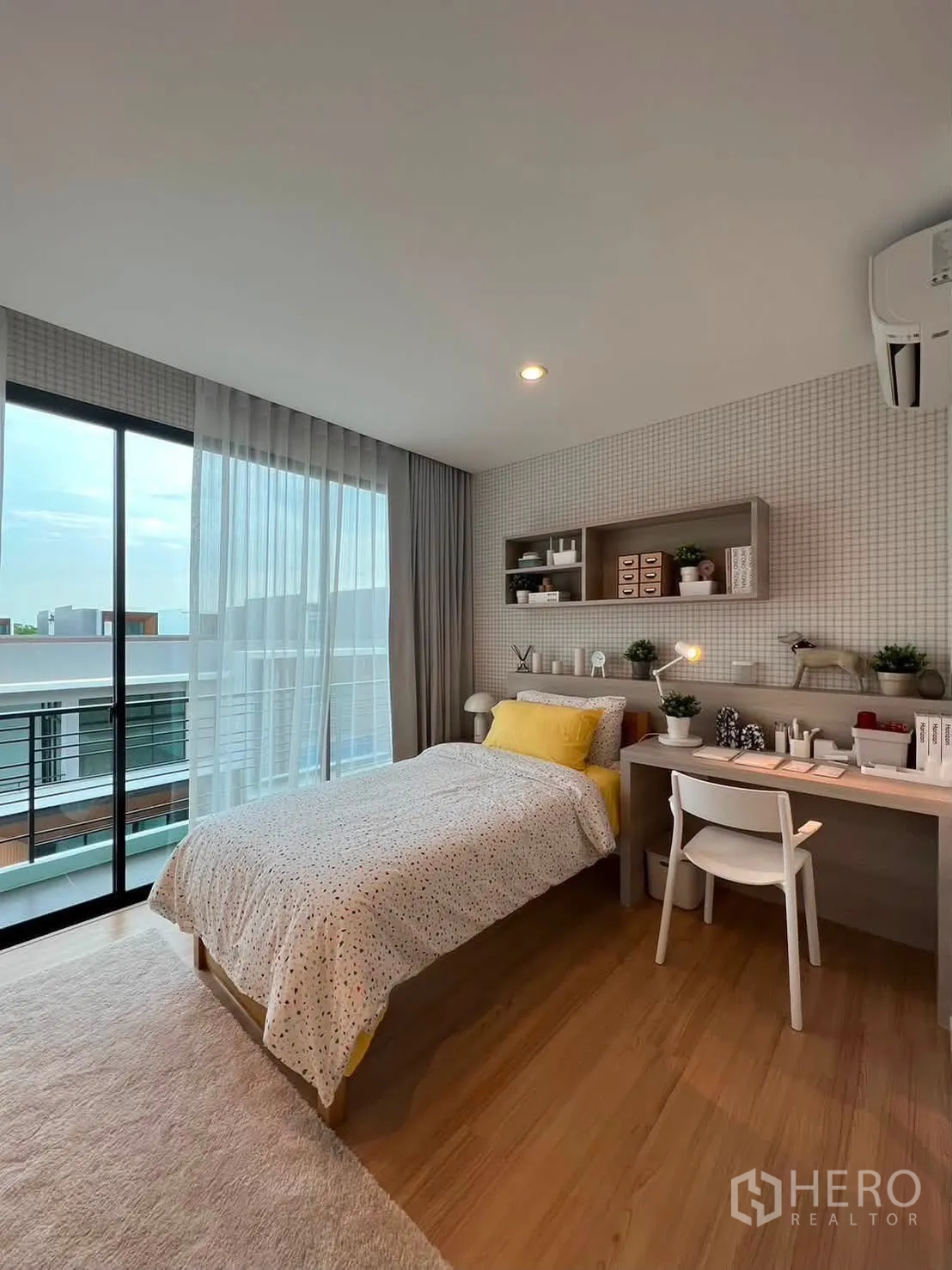 Townhouse for rent in Saphan Sung, Bangkok - Cozy bedroom with single bed, desk, air conditioner, and sliding glass doors.