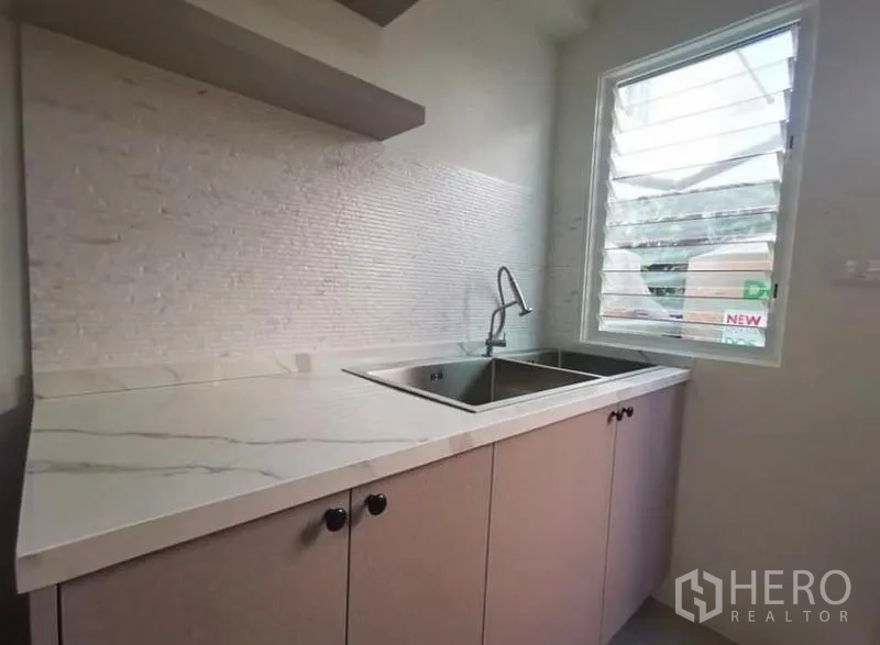 独立式住宅 出租 - 后厨，双槽水槽、大理石纹台面与百叶窗。