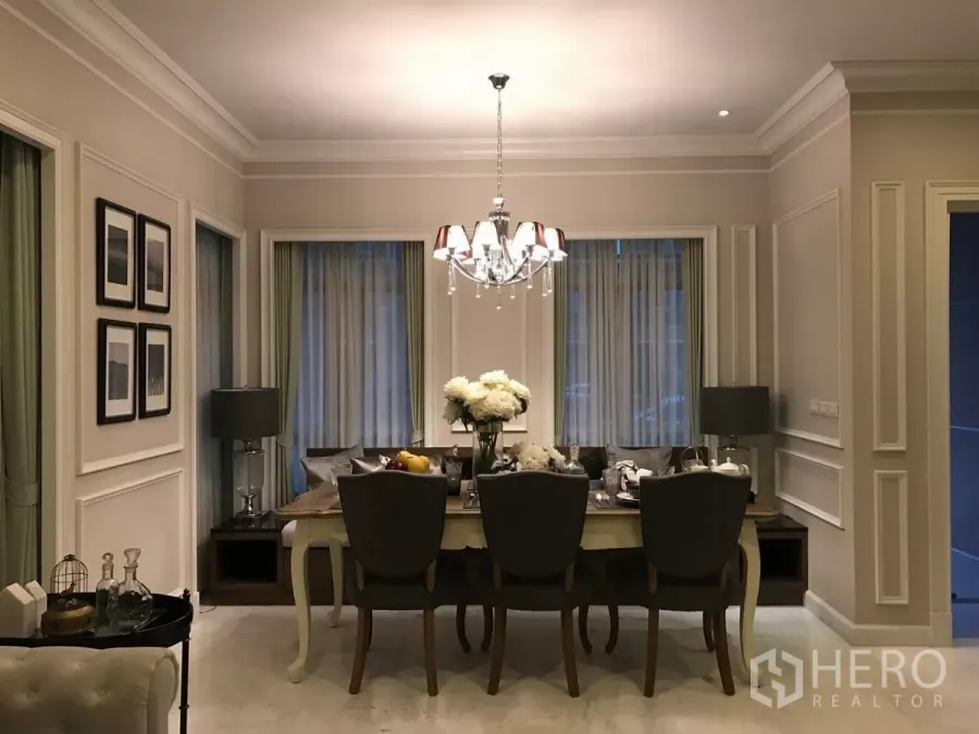Townhouse for sale in Watthana, Bangkok - Elegant dining room with chandelier, classic wall molding and curtained windows.