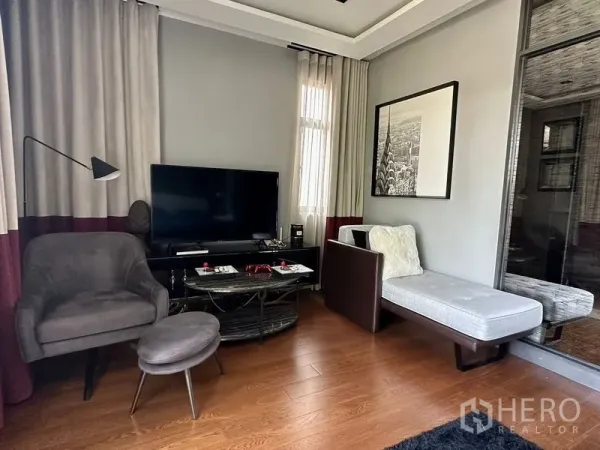 บ้าน ให้เช่าในPhra Khanong, Bangkok - มุมนั่งเล่นพร้อมทีวี เก้าอี้นวมและโซฟา ใกล้หน้าต่างบานใหญ่