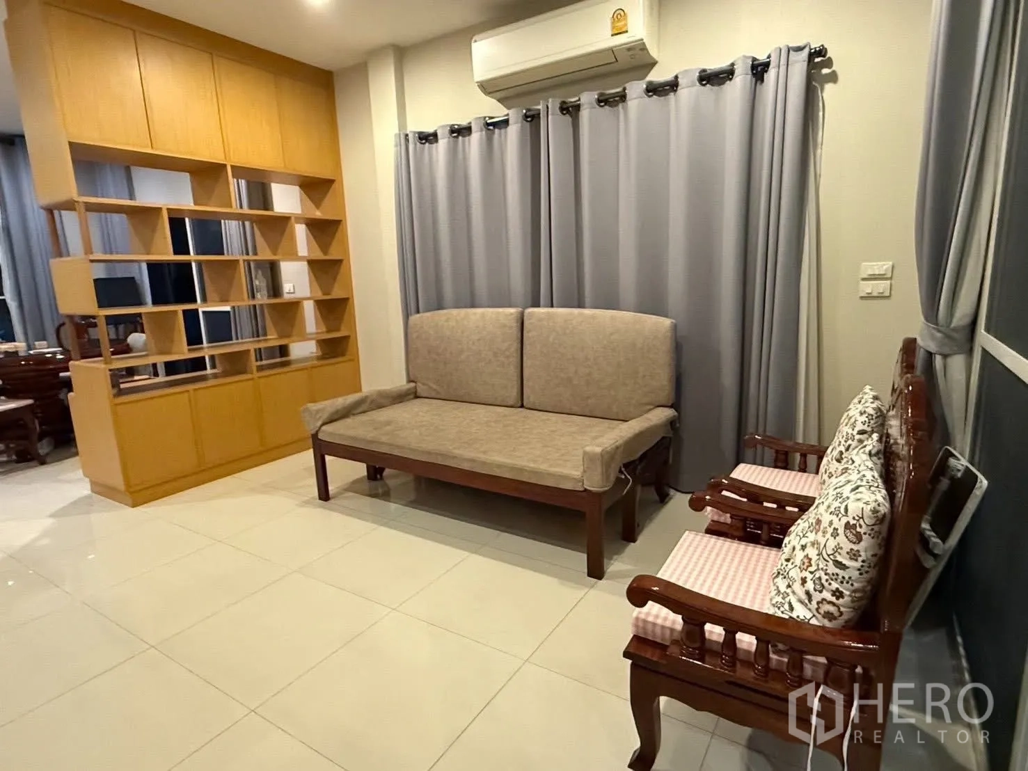 Detached House for rent in Bang Na, Bangkok - Bright living area with tiled floors, sofa set, curtains and built-in shelving.