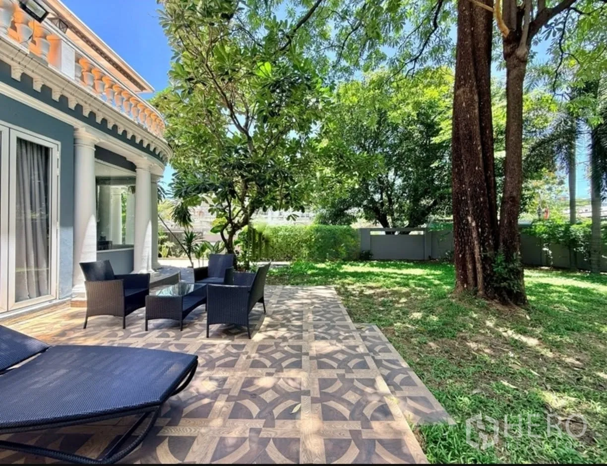 บ้านเดี่ยว for rent in Phra Khanong, Bangkok - เฉลียงกลางแจ้งพร้อมชุดเก้าอี้หวายและเตียงอาบแดดข้างสนามหญ้า