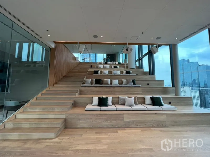 Condominium for rent in Bang Rak, Bangkok - Sky lounge with tiered seating and panoramic city views behind glass walls.
