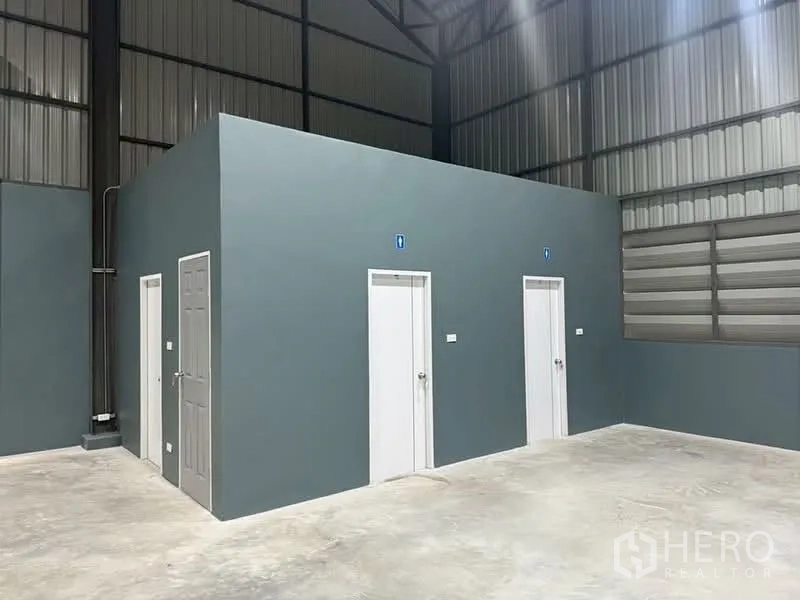 Factory for rent in Khlong Luang, Pathum Thani - Internal utility block with multiple restroom doors inside the warehouse.