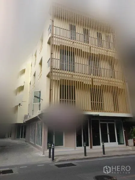 零售空间 出租在Khlong Toei, Bangkok - 转角建筑外观，竖向格栅立面与一层店铺门面