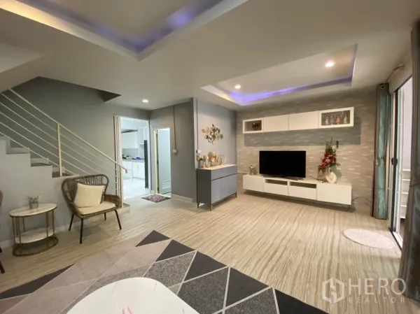 联排别墅 出租或出售 - 现代客厅，氛围灯顶、电视背景墙与通往二层的楼梯。