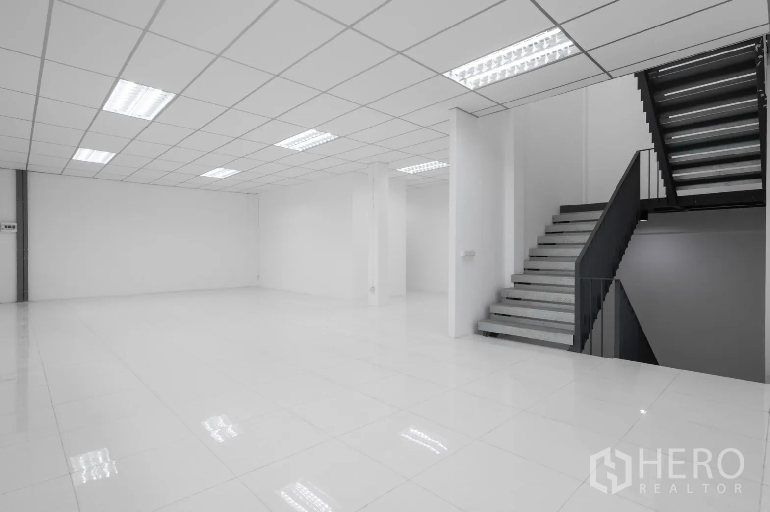 Factory for rent in Pathum Thani - Bright ground-floor office with staircase connecting to the upper level.