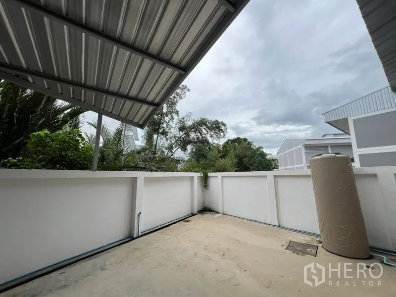 โรงงาน ให้เช่าในPhra Samut Chedi, Samut Prakan - ลานงานบริการด้านหลังใต้หลังคาเมทัลชีท พร้อมกำแพงรั้วและแทงค์น้ำ