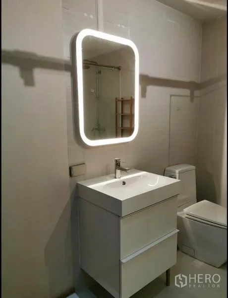 คอนโด ให้เช่าในKhlong Toei, Bangkok - ตู้ล้างหน้าพร้อมกระจกไฟและโถสุขภัณฑ์ในห้องน้ำสว่าง
