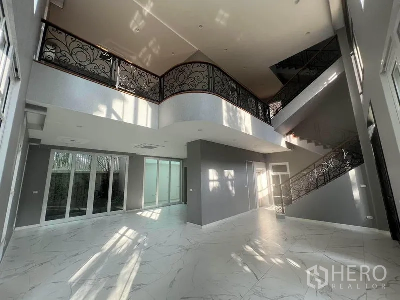 บ้าน ขายในYan Nawa, Bangkok - ห้องนั่งเล่นเพดานสูงโปร่ง พื้นลายหินอ่อน พร้อมบันไดเหล็กดัดลวดลาย