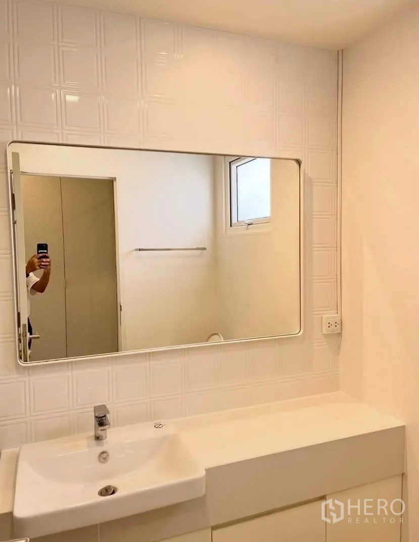 Detached House for rent in Bang Phli, Samut Prakan - Bathroom vanity with large mirror, sink, and a small window.