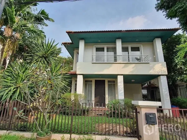 Detached House for rent in Wang Thonglang, Bangkok - Two-storey detached house exterior with balcony, fenced front garden and mature trees.