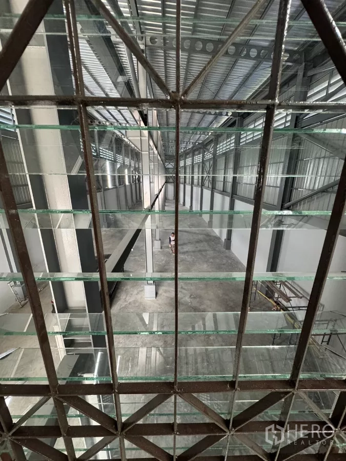 Warehouse for rent in Bang Khun Thian, Bangkok - View through a glass grid over the warehouse hall and steel trusses.