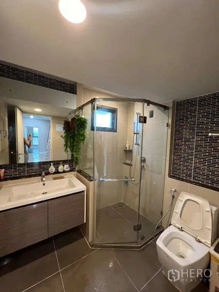Detached House for rent in Bang Kapi, Bangkok - Contemporary bathroom with glass shower enclosure, vanity and toilet.