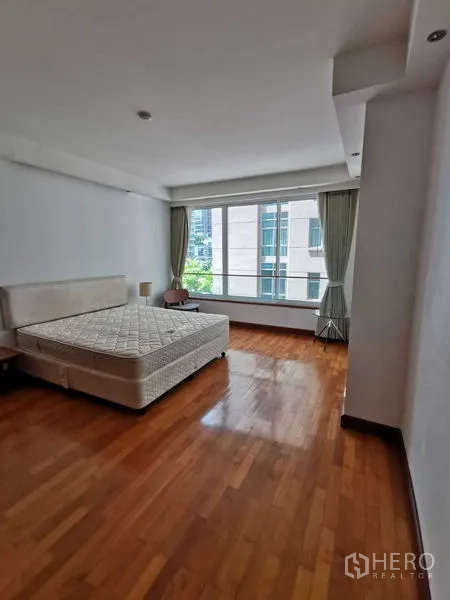 Condominium for rent in Pathum Wan, Bangkok - Bedroom with big window, city outlook, and polished wood flooring.