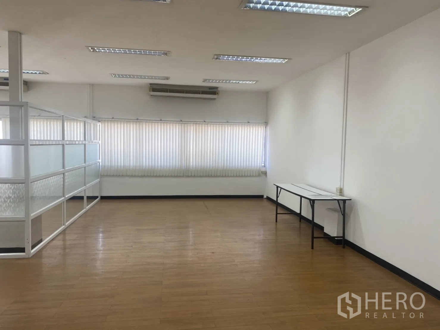 Office Space for rent in Khlong Toei, Bangkok - Spacious office area with a long window wall, air-conditioning units, and a glass-partitioned meeting zone.